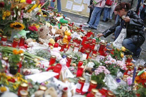 Eine Mutter zündet an Michelles Grundschule eine Kerze an