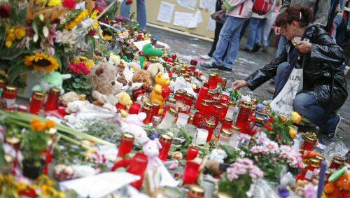 Eine Mutter zündet an Michelles Grundschule eine Kerze an Eine Mutter zündet an Michelles Grundschule eine Kerze an
