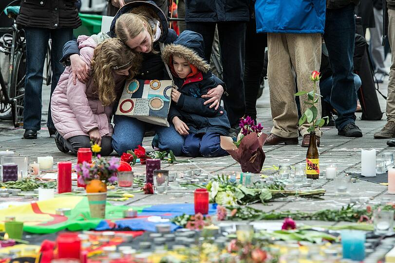 Eine Frau legt mit ihren Kindern am Place de la Bourse Blumen nieder für die Opfer der Brüsseler Terroranschläge.