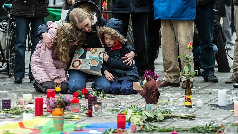 Eine Frau legt mit ihren Kindern am Place de la Bourse Blumen nieder für die Opfer der Brüsseler Terroranschläge. Eine Frau legt mit ihren Kindern am Place de la Bourse Blumen nieder für die Opfer der Brüsseler Terroranschläge.