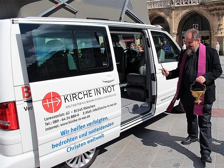 Der Fahrer weiht seinen Wagen: Pater Hermann-Josef Hubka am "Beichtmobil"
