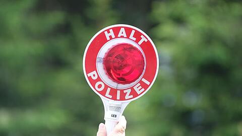 Eine Polizistin hält bei einer Verkehrskontrolle eine Winkerkelle in die Höhe. Foto: Sebastian Willnow/zb/dpa/Symbolbild