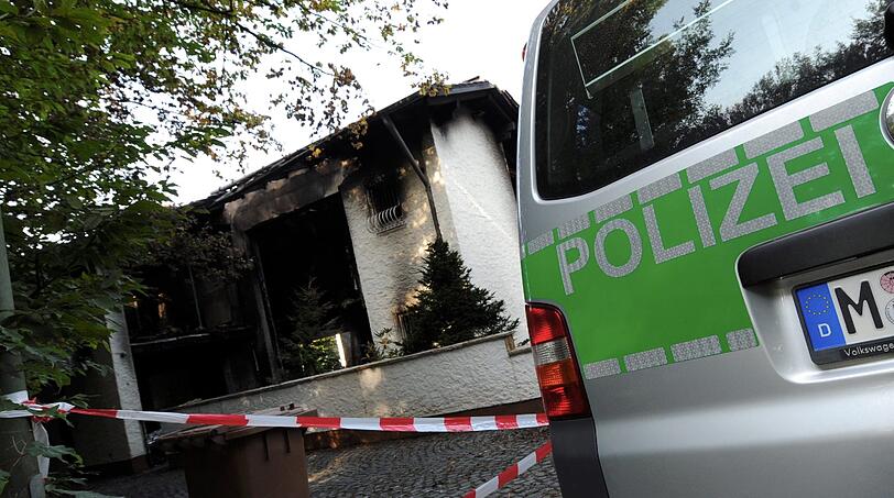 Blick auf die verkohlte Villa des Bayern-Stars Breno: Auch nach Tagen stehen noch Dienstfahrzeuge der Polizei vor dem Anwesen in Grünwald