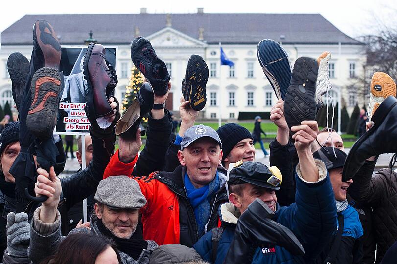 Mit hochgehaltenen Schuhen stehen Demonstranten am Samstag vor Schloss Bellevue in Berlin, dem Amtssitz von Bundespräsident Christian Wulff.