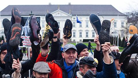Mit hochgehaltenen Schuhen stehen Demonstranten am Samstag vor Schloss Bellevue in Berlin, dem Amtssitz von Bundespräsident Christian Wulff.