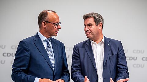 Markus Söder (CSU, r), Ministerpräsident von Bayern und CSU-Vorsitzender, spricht mit Friedrich Merz, CDU Bundesvorsitzender.