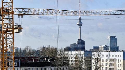 Der Fernsehturm am Alexanderplatz ist hinter Baukränen und Mietshäusern zu sehen. Als erstes Bundesland führt Berlin den Mietendeckel ein.