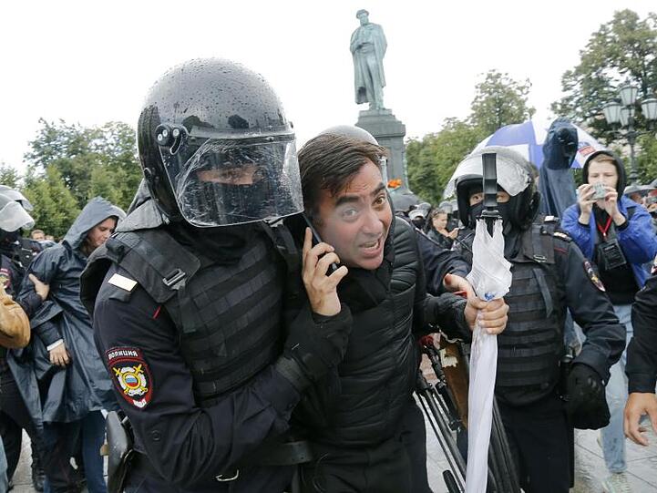 Polizisten führen Demonstranten ab.