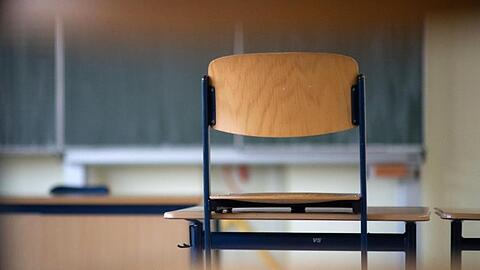 Ein Stuhl in einem Klassenzimmer auf einem Tisch. Wann sollen die Schulen öffnen?.