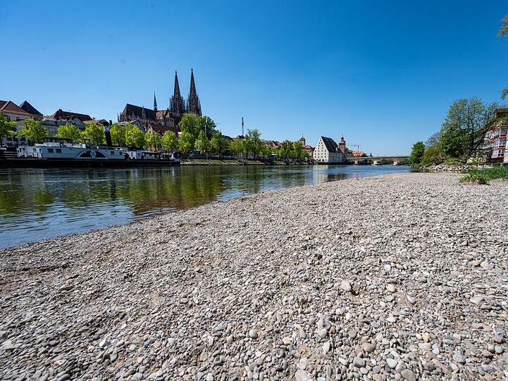 Kies liegt am Ufer der Niedrigwasser führenden Donau in Regensburg. Foto: Armin Weigel/dpa