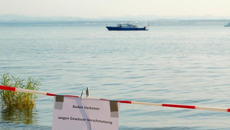 Ein Uferabschnitt am Bodensee bei Friedrichshafen ist mit einem Hinweisschild und einem Absperrband für Badegäste gesperrt. Foto: Marcus Fey Ein Uferabschnitt am Bodensee bei Friedrichshafen ist mit einem Hinweisschild und einem Absperrband für Badegäste gesperrt. Foto: Marcus Fey