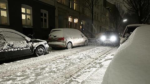 Ein Auto fährt auf einer verschneiten Straße. Starker Schneefall hat Hamburg am Abend überrascht.