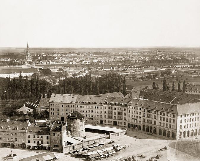 1858: Blick auf den Viktualienmarkt mit dem Rest der alten Stadtmauer und dem Scheibling-Wehrturm.