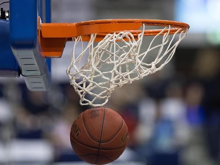 Ein Basketball fällt durch das Netz vom Basketballkorb. Foto: Lukas Schulze/dpa/Archiv/Symbolbild