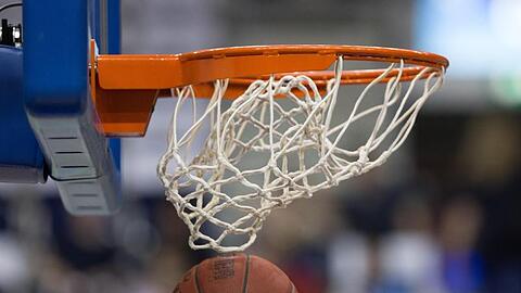 Ein Basketball fällt durch das Netz vom Basketballkorb. Foto: Lukas Schulze/dpa/Archiv/Symbolbild