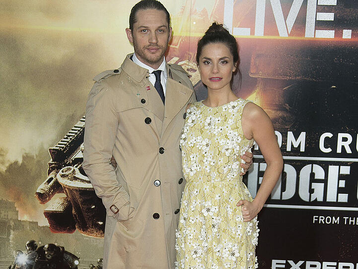 Schauspieler Tom Hardy trägt einen beigen Trenchcoat über schickem Anzug auf der Premiere von "Edge of Tomorrow"