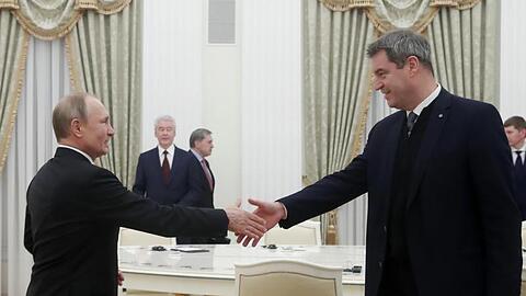 Wladimir Putin und Markus Söder geben sich die Hand. Foto: Maxim Shemetov/Pool Reuters/AP/dpa