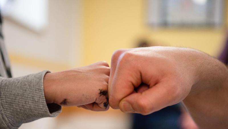 Ein Insasse gibt in der Vater-Kind-Gruppe in der JVA Nürnberg seinem Sohn einen Fist Bump. Ein Insasse gibt in der Vater-Kind-Gruppe in der JVA Nürnberg seinem Sohn einen Fist Bump.