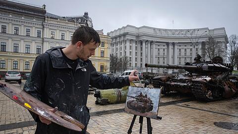 Der britische Künstler Max Denison-Pender malt in Kiew eine Ausstellung beschädigter russischer Panzer.