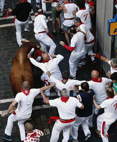 Die Läufer tragen traditionelle Kleidung: weißes Hemd, weiße Hose, rotes Halstuch.