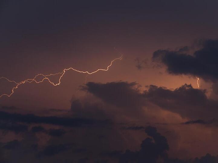 Blitze leuchten während eines Gewittersturms am Himmel. Foto: Nicolas Maeterlinck/BELGA/dpa/Symbolbild