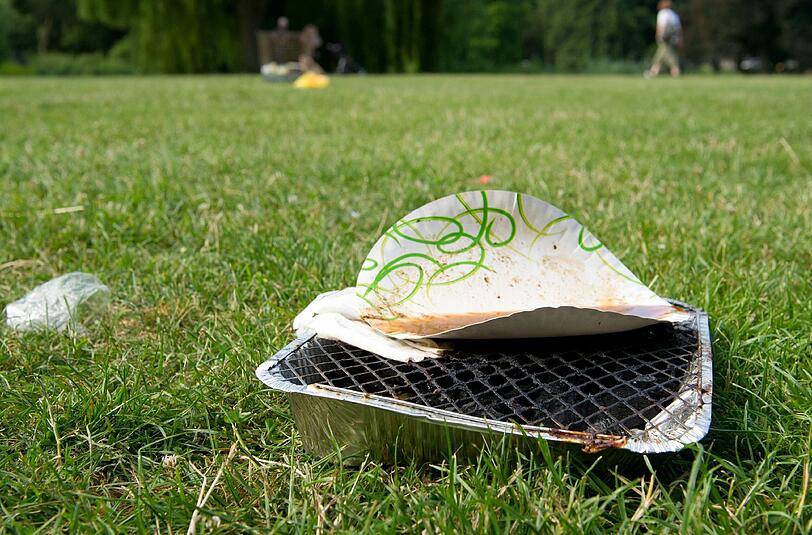 Einweggrills hinterlassen oft unschöne Brandlöcher im Gras.