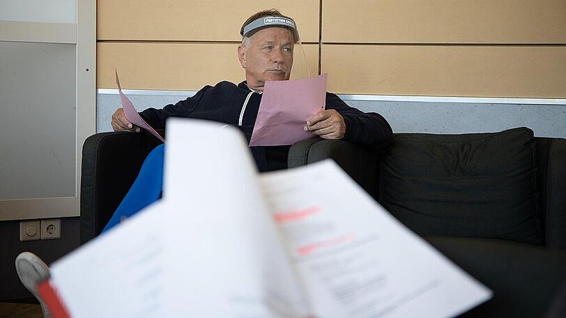 Schauspieler Thomas Rühmann mit Visier bei einer Textprobe.