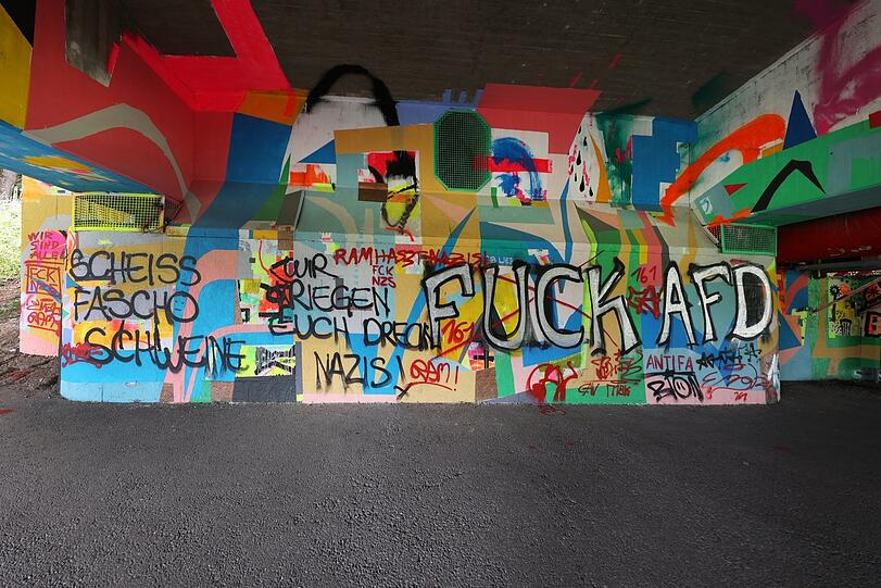 Unter der Brücke in den Isarauen: Polit-Graffiti mit einer klaren Ansage.