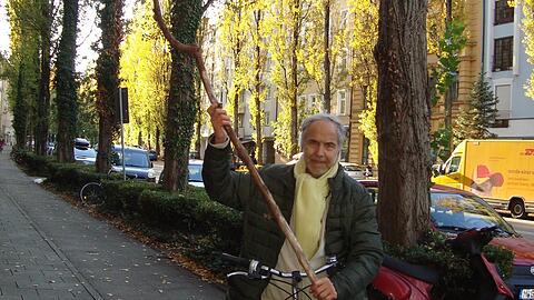 Passt gar nicht ganz aufs Bild: Jürgen Schilling mit dem Aststück, das ihm beinahe auf den Kopf gefallen wäre am Unglücksort in der Lindwurmstraße.