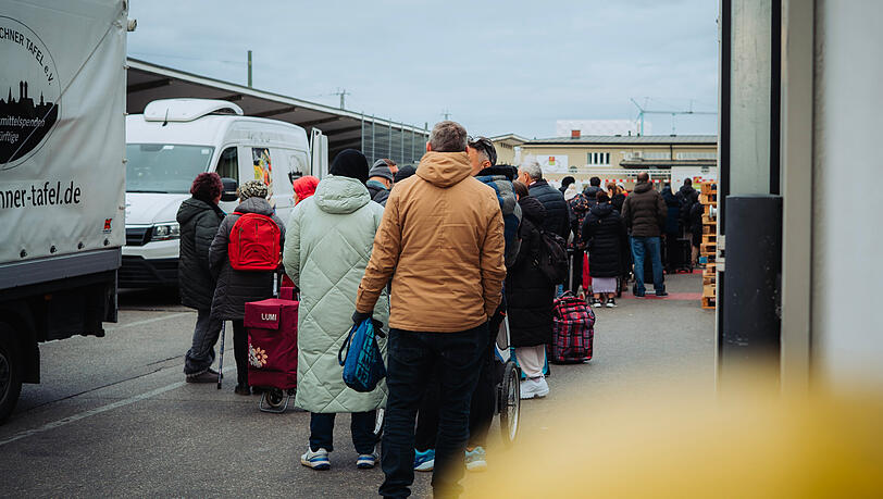 Hunderte Menschen warten auf Lebensmittel f&uuml;r die Woche.