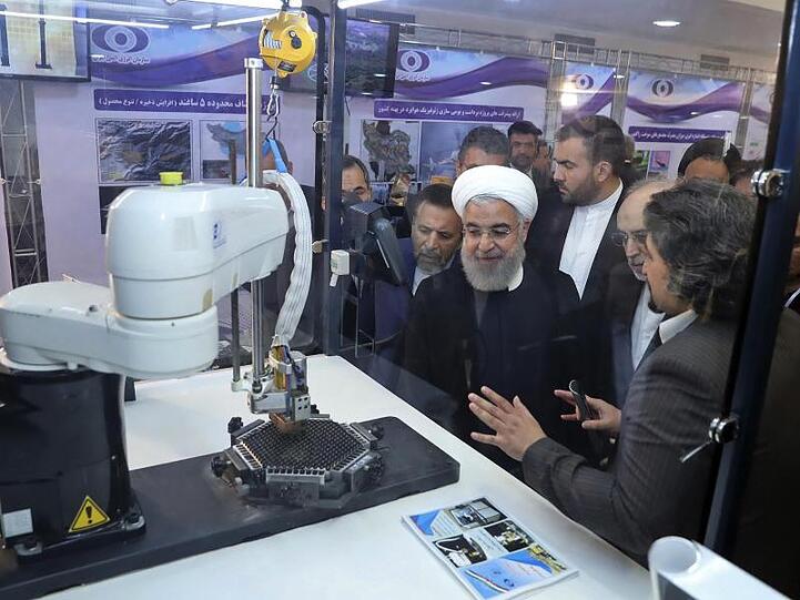 Der iranische Präsident Hassan Ruhani (M.) lässt sich neue Entwicklungen in der Atomenergie im Rahmen des "Nationalen Atomtags" erklären.