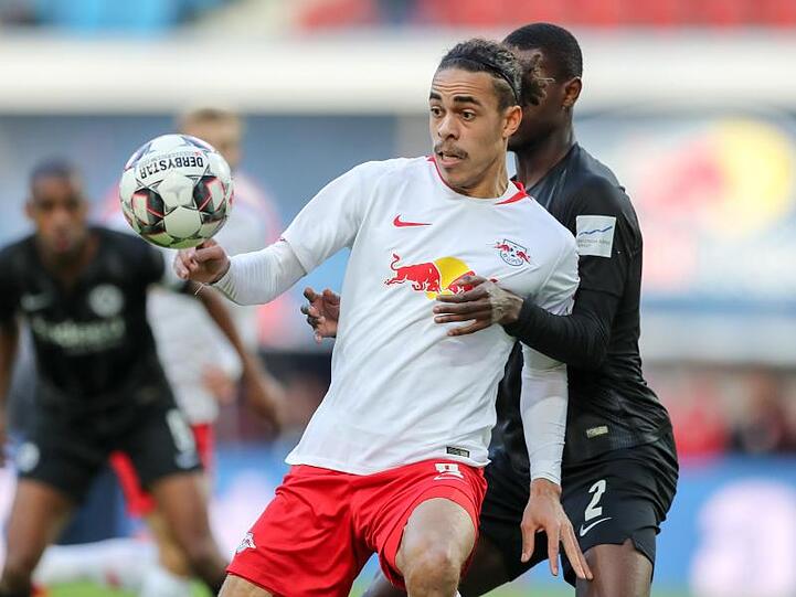Leipzigs Yussuf Poulsen (l) schirmt den Ball vor Frankfurts Evan Ndicka ab.
