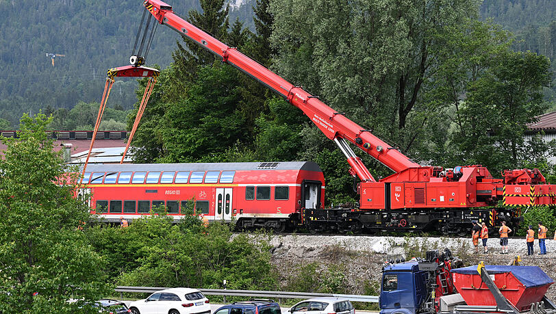 Ein Waggon des verunfallten Regionalzugs hängt für die Bergung an einem Schienenkran.