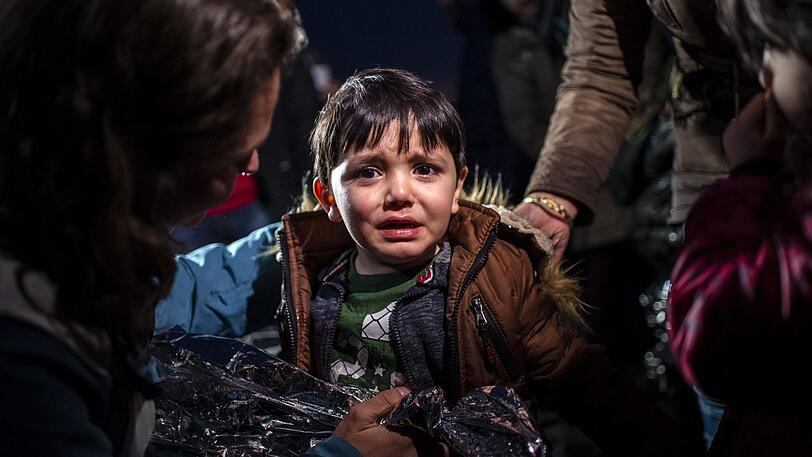 Ein Junge weint am Strand des Dorfes Skala Sikamias auf Lesbos nach seiner Ankunft aus der Türkei mit einem Schlauchboot.