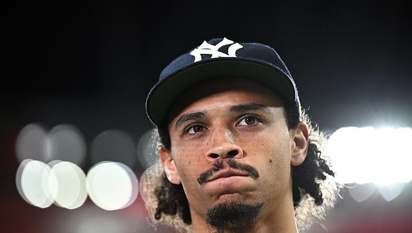 Leroy Sané steht vor dem Spiel während eines Interviews am Spielfeldrand.