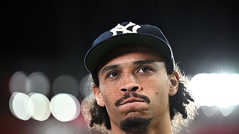 Leroy Sané steht vor dem Spiel während eines Interviews am Spielfeldrand.