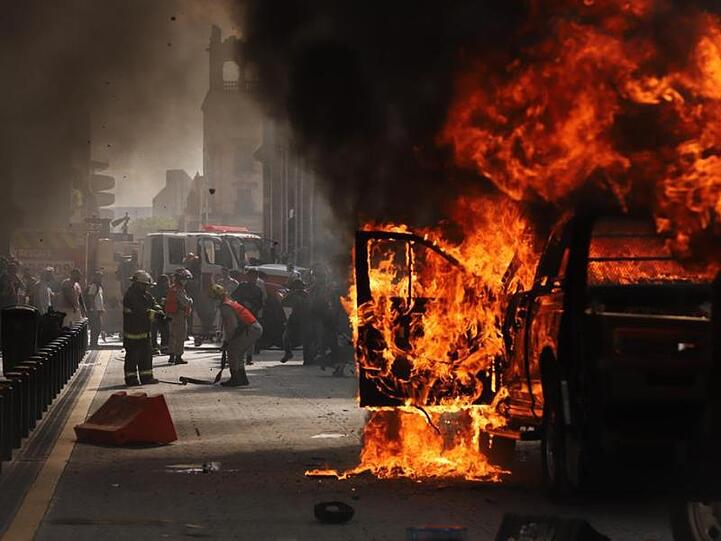 Ein Fahrzeug steht in Flammen. Auch in Mexiko hat es Proteste wegen des Todes eines Mannes nach dessen Festnahme durch die Polizei gegeben.