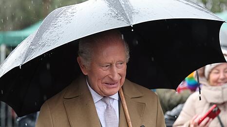 König Charles trotzt in Wales dem Regen.