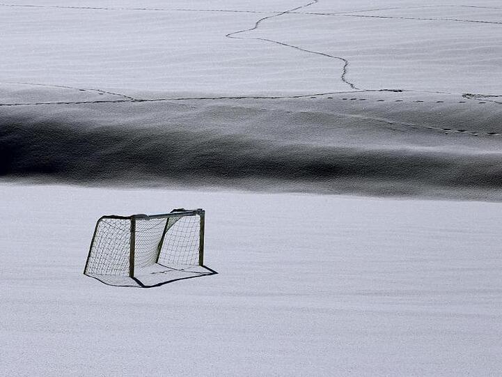 Ein Tor steht auf einem Fußballplatz inmitten des frisch gefallenen Schnees. Foto: Karl-Josef Hildenbrand