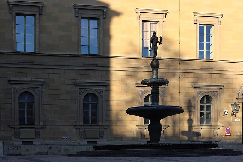 Der Kronprinz-Rupprecht-Brunnen mit Schattenwurf an der Wand.
