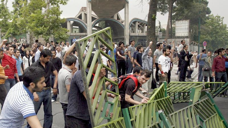 Demonstranten reißen Straßenbarrikaden der Polizei in Teheran nieder. Demonstranten reißen Straßenbarrikaden der Polizei in Teheran nieder.