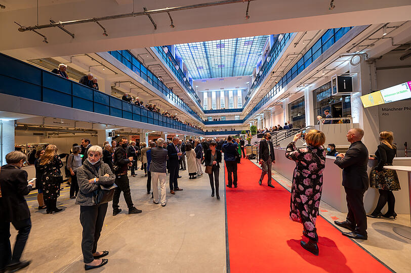 Besucher stehen zu Beginn der Eröffnung der Isarphilharmonie im Atrium des Gebäudes.