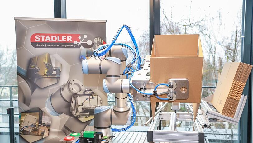 Dieser Cobot kann selbstständig Schachteln falten. Die Roboter sind durch die Verwendung von Kunststoff und Aluminium besonders leicht.