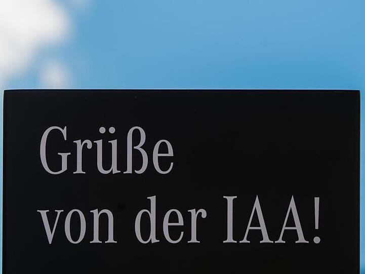 Auf dem Schild eines Ausstellers der Internationalen Automobil-Ausstellung (IAA) steht "Grüße von der IAA".