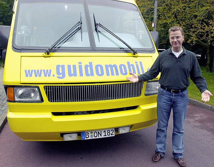 Hier posiert er vor seinem legendärem Guidomobil.