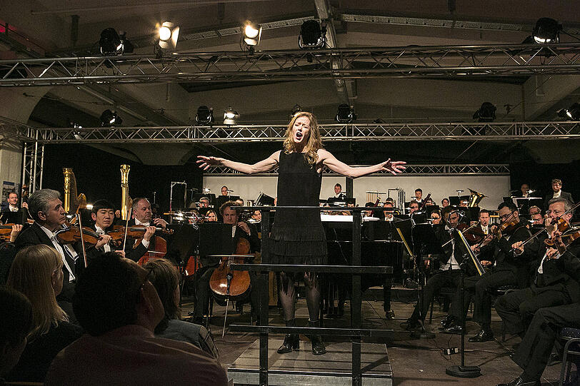 Die kanadische Dirigentin Barbara Hannigan singend an ungewöhnlichem Ort vor den Münchner Philharmonikern, die gleich mitsingen mussten: &bdquo;Embraceable You!&ldquo;.