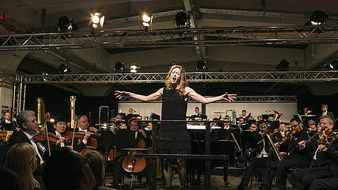 Die kanadische Dirigentin Barbara Hannigan singend an ungewöhnlichem Ort vor den Münchner Philharmonikern, die gleich mitsingen mussten: &bdquo;Embraceable You!&ldquo;.