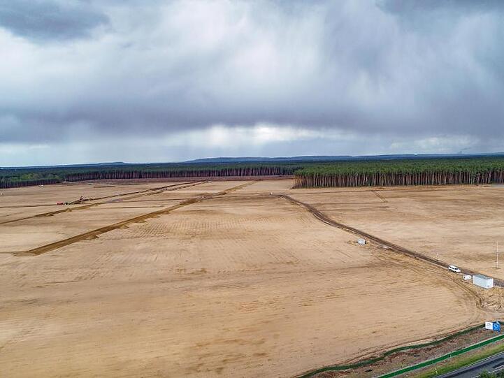 Dunkle Regenwolken ziehen über die Baufläche der künftigen Tesla Giga-Factory in Grünheide.