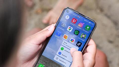 Eine Frau hält ein Smartphone in den Händen. (Symbolbild)