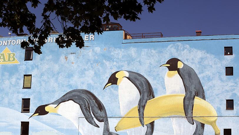 Drei Pinguine tragen eine Banane – die Seitenwand vom Kontorhaus Brunthaler an der Thalkirchner Straße. Drei Pinguine tragen eine Banane – die Seitenwand vom Kontorhaus Brunthaler an der Thalkirchner Straße.
